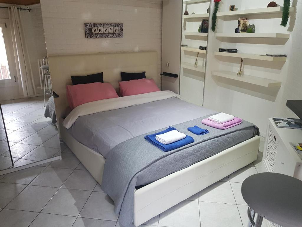Schlafzimmer mit einem Bett mit blauen und rosa Kissen in der Unterkunft Sweet Apartment Suite Castelmerlo in Bologna