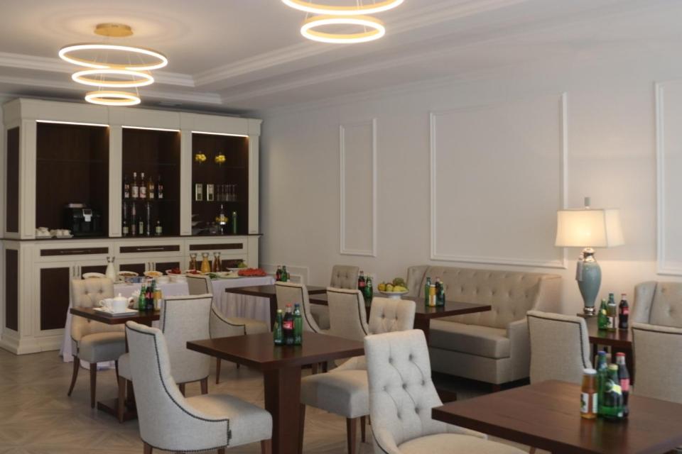 a restaurant with tables and chairs and a bar at Union Hotel Grozny in Groznyy