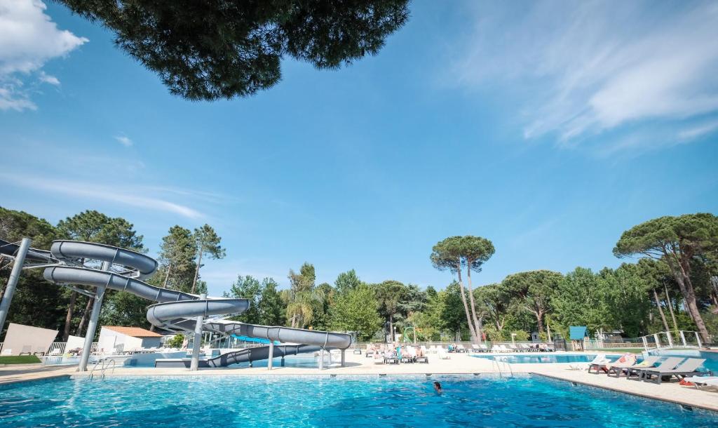 a water slide in a swimming pool at Camping Taxo Les Pins - Maeva in Argelès-sur-Mer