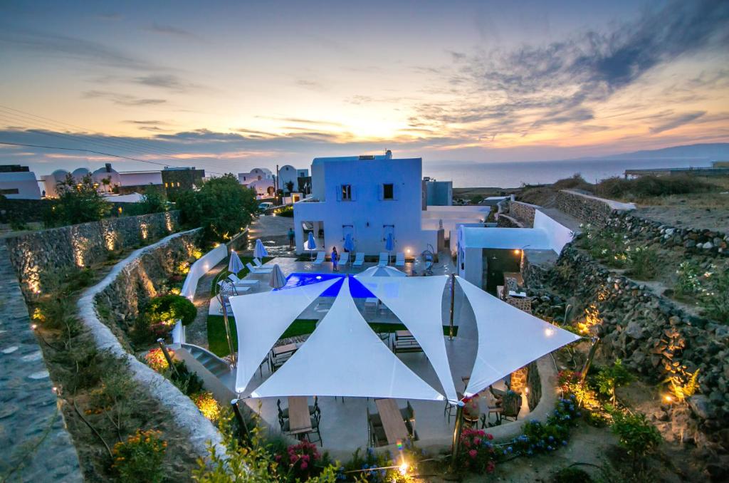 eine Luftansicht eines weißen Gebäudes mit Sonnenuntergang in der Unterkunft Apanomeria Boutique Residence in Oia