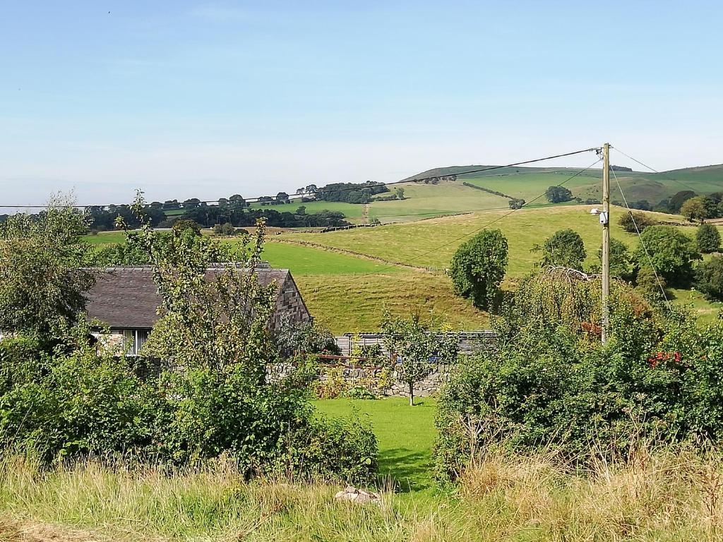 ein Haus mitten auf einem grünen Feld in der Unterkunft The Milk Barn in Ashbourne