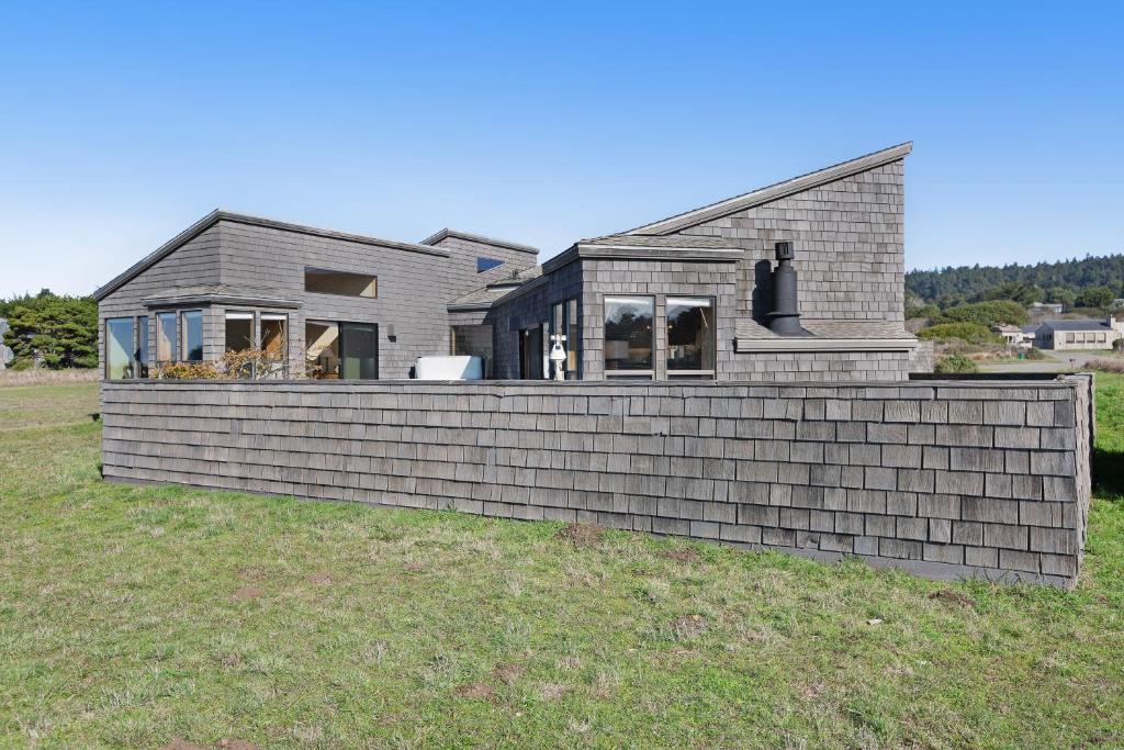 a house with a retaining wall in a field at Windrow Retreat in Sea Ranch
