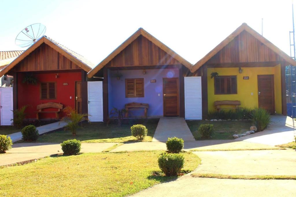 a row of cottages with colorful at Chácara Bora Bora in São Bento do Sapucaí