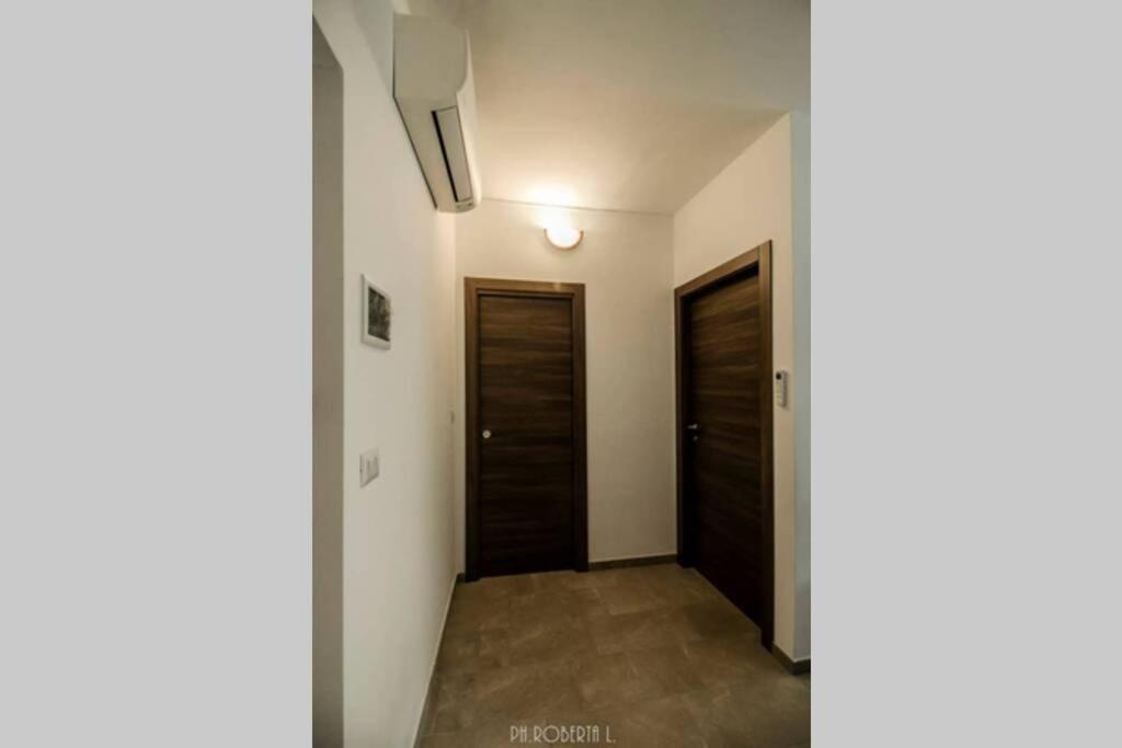 um corredor com duas portas de madeira e um corredor em Accogliente Bussana 2 em Sanremo