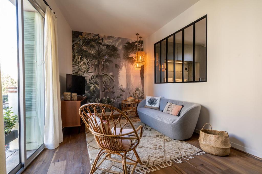 een woonkamer met een bank en een stoel bij Suite in St Raph in Saint-Raphaël