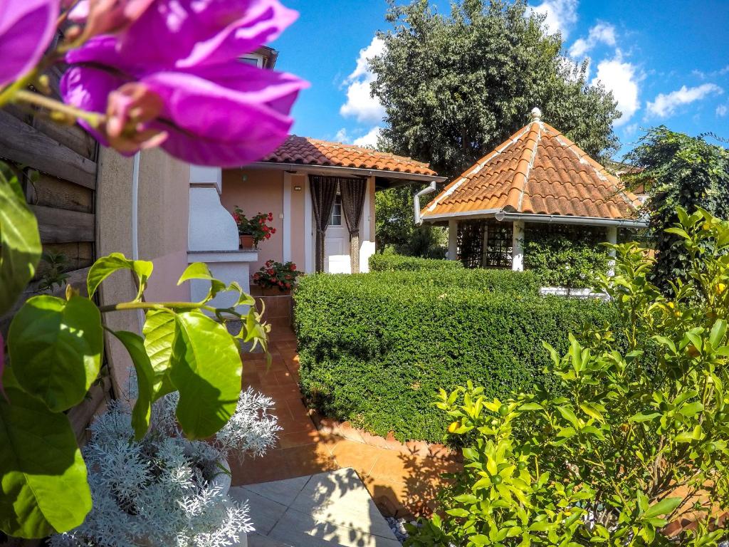 un giardino con una casa di fiori viola di Apartments Vintijan a Pola (Pula)