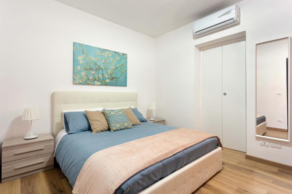 een slaapkamer met een bed en een schilderij aan de muur bij Centre Apartment Grotte Bianche 2 in Catania