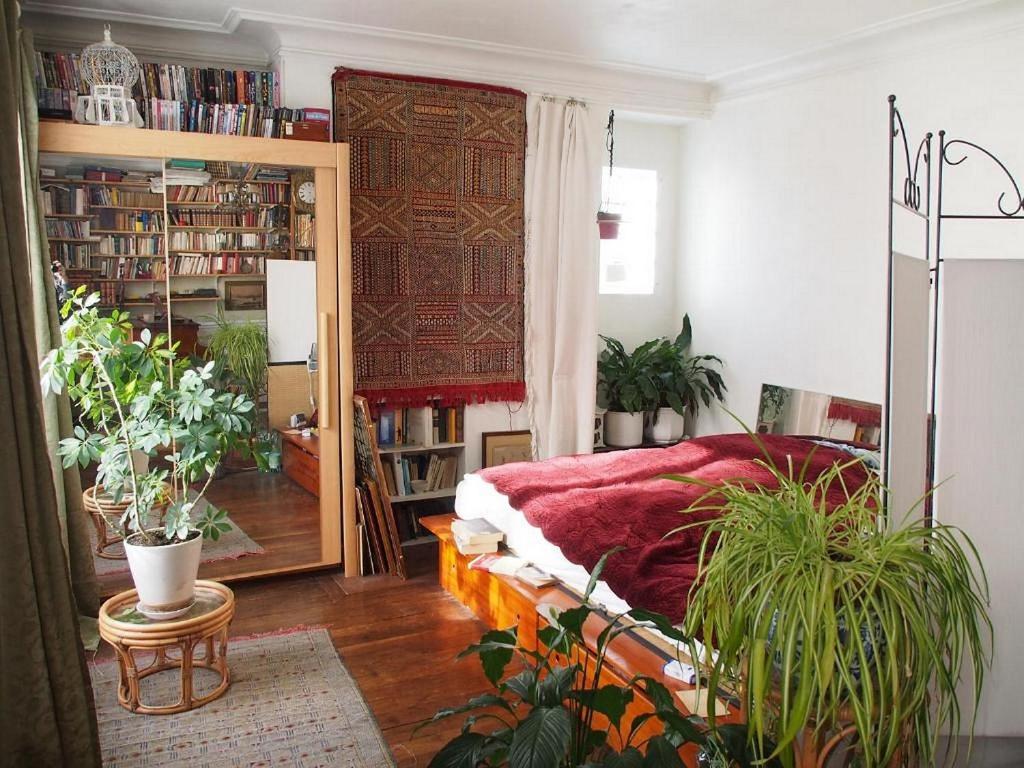 a room with a bed and a mirror and plants at Very large private room with own bathroom, in Montmartre apartment in Paris