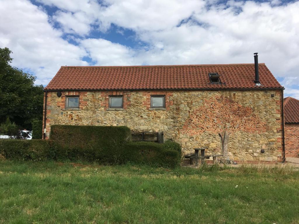 ein altes Backsteinhaus mit rotem Dach in der Unterkunft Horizon Barn in Market Rasen