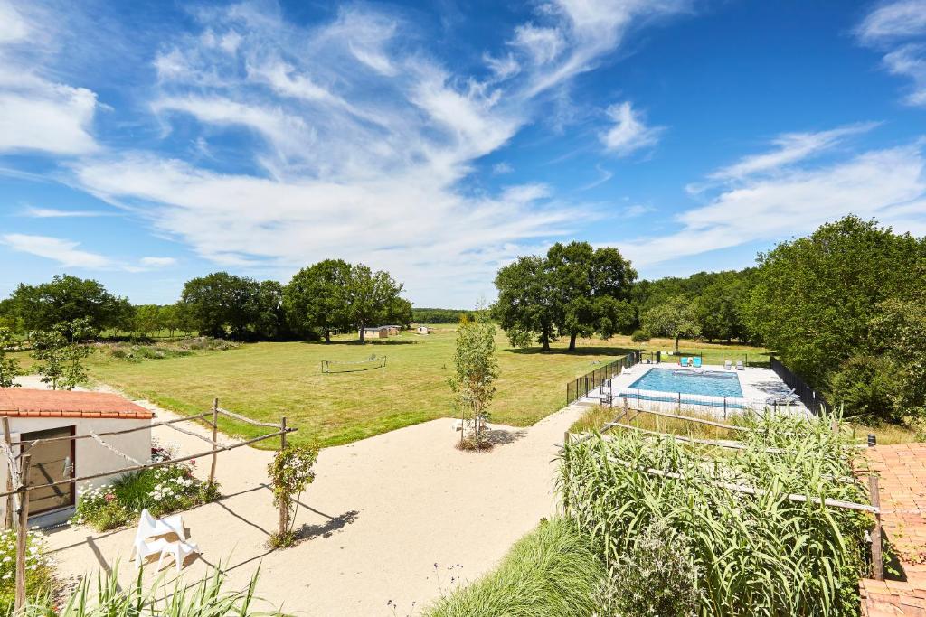 an image of a backyard with a swimming pool and trees at Domaine de l'Oiselière in Chauché