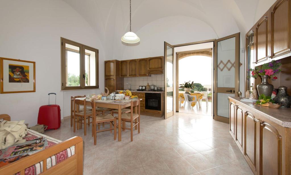 una cucina con tavolo e sedie e una cucina con sala da pranzo di Villa Carol a Torre Vado