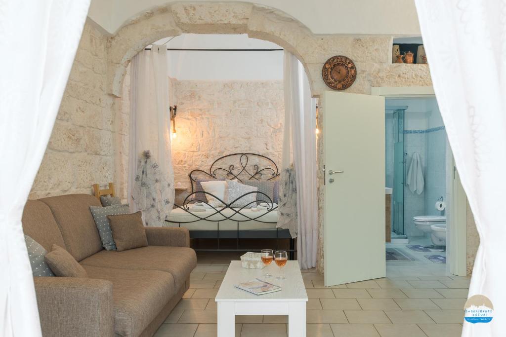 - un salon avec un canapé et un lit dans l'établissement Casa Francesca, à Ostuni