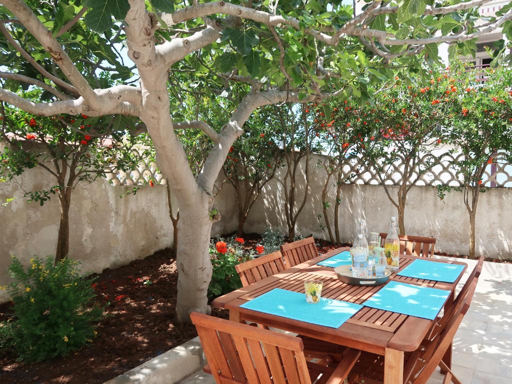 a wooden table and chairs under a tree at La Baia Mare in Torre Lapillo