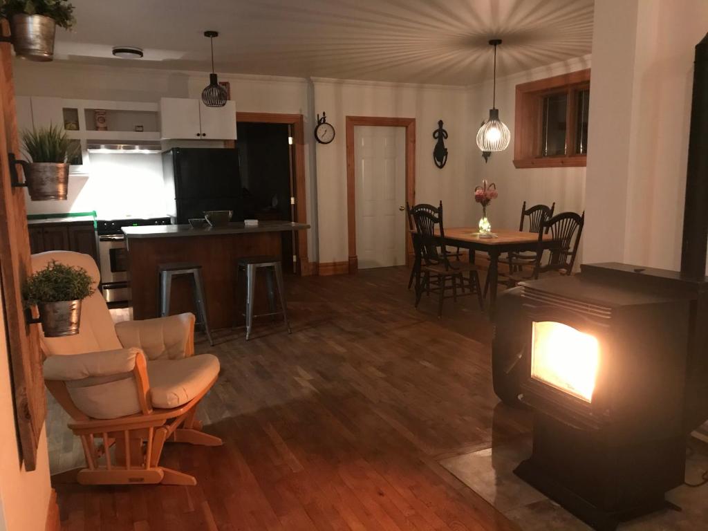 un soggiorno con camino e cucina di Stopover-halte repos foyer clim a Montmagny