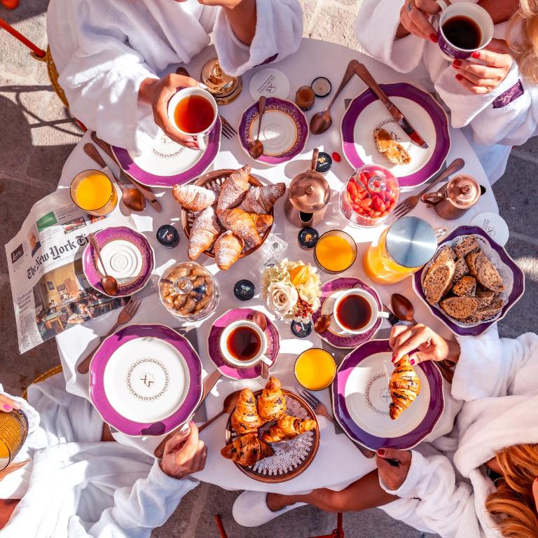 a group of people sitting around a table with food at Excess Venice Boutique Hotel & Private Spa - Adults Only in Venice