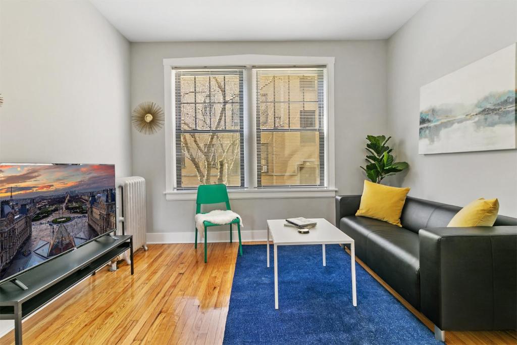 uma sala de estar com um sofá e uma televisão em Elegant 1BR Apartment close to Shops - Belmont C2 em Chicago