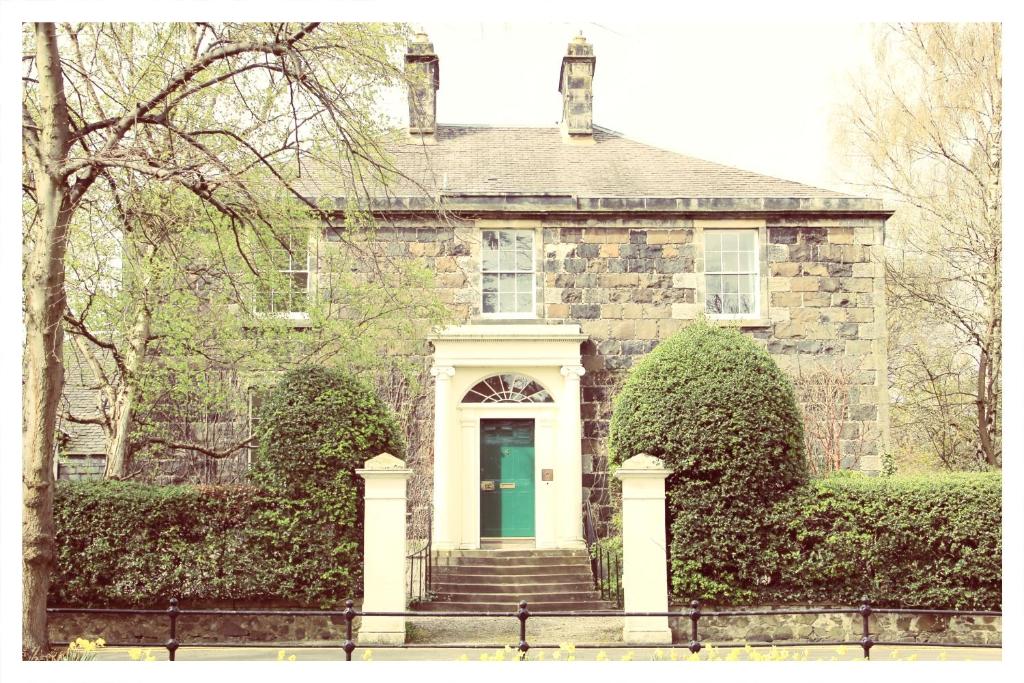 an old stone house with a green door at A Luxurious Masterpiece Steps from Stirling in Stirling