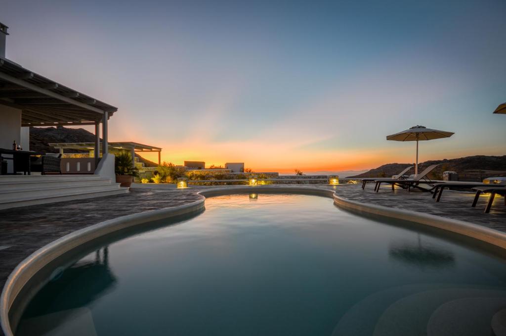 a swimming pool with a sunset in the background at Naxos Secret Paradise Villa in Galini