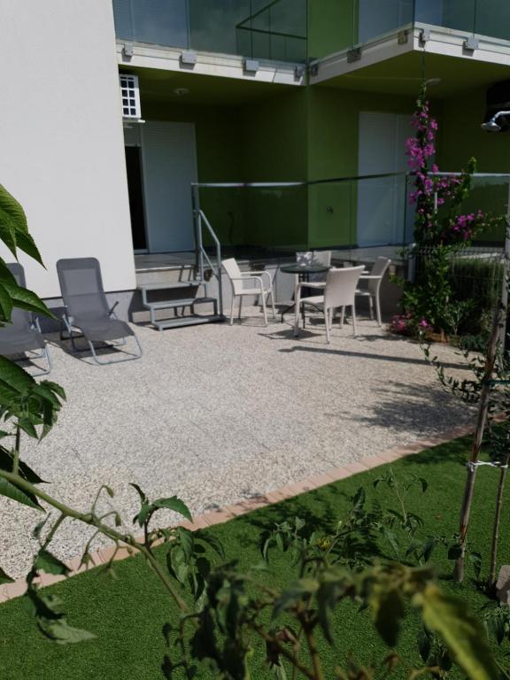 un patio con sedie e tavoli in un edificio di Apartmani Matko a Nin