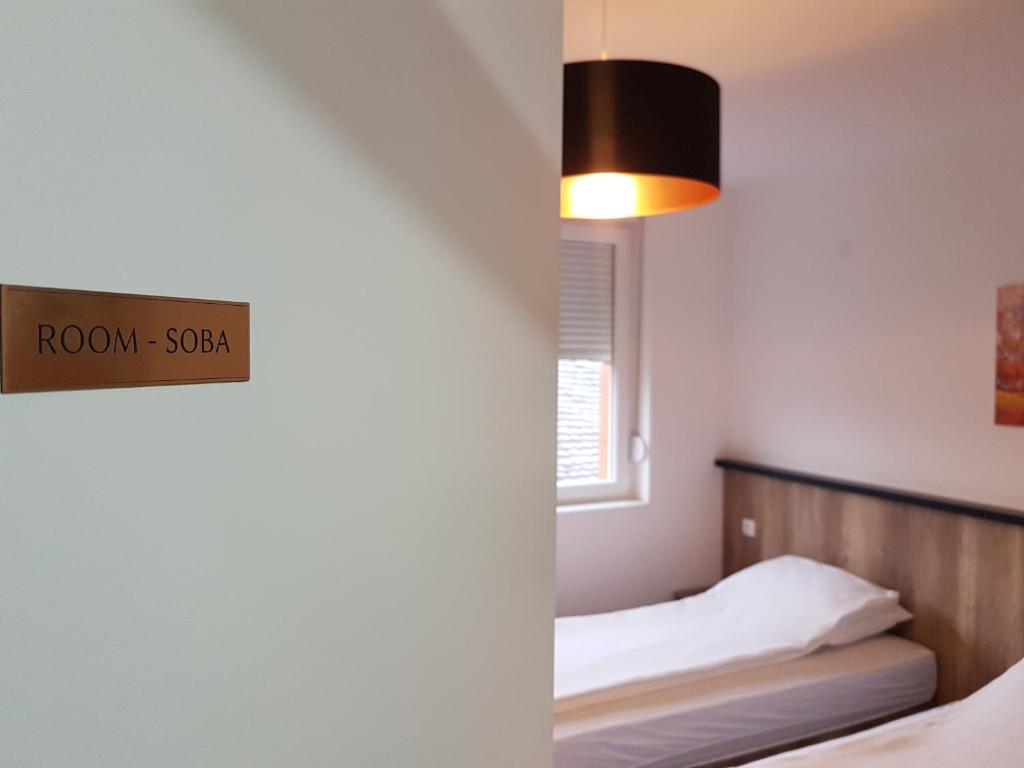 a bedroom with a bed and a sign that reads room spa at Apartmani Simić Quatro in Valjevo