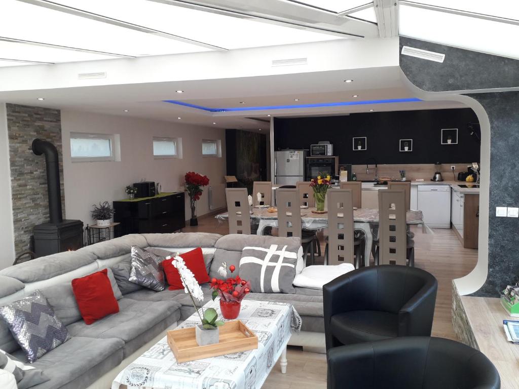 a living room with a couch and a table and a kitchen at Gite familial à Carentan in Carentan