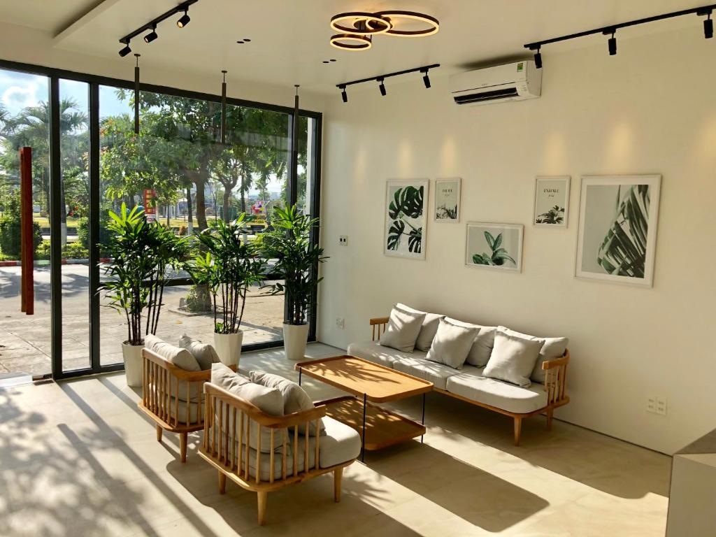 uma sala de estar com um sofá, cadeiras e uma mesa em Coconut Hotel Phú Yên em Tuy Hoa