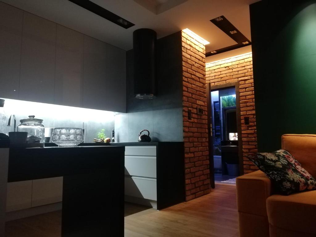 cocina con encimera negra y pared de ladrillo en Apartament na Mazurach, en Ełk