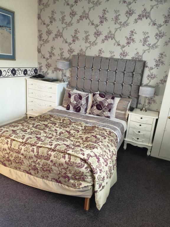 a bedroom with a large bed and two night stands at No 26 rooms in Inverness