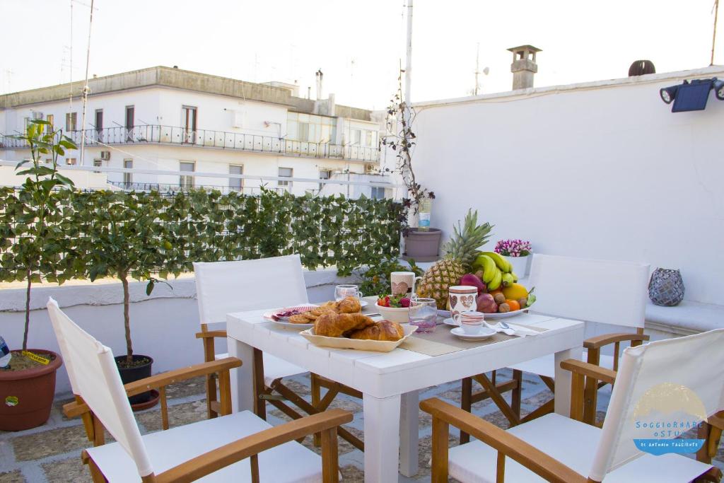 a white table with food on it on a balcony at Casa Filomena in Ostuni