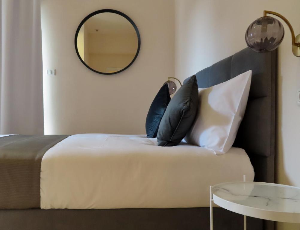 a bedroom with a bed with pillows and a mirror at B12 Inn in Jerusalem