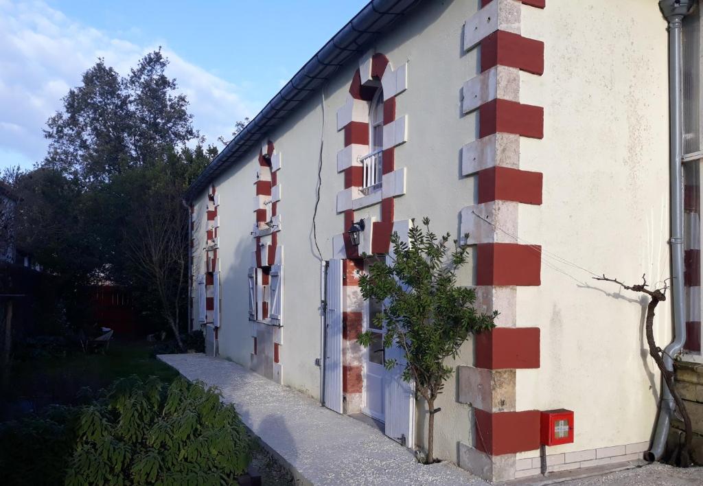 a building with red and white squares on it at Manor House Charentaise in Sainte-Soulle