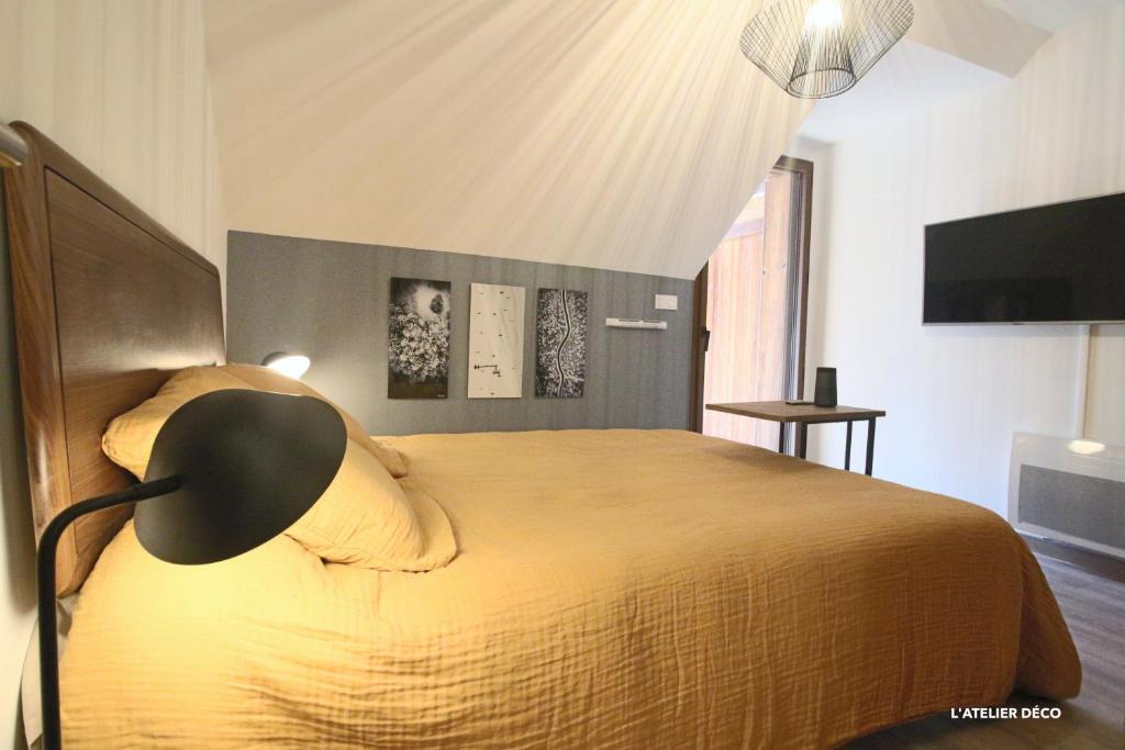 a bedroom with a large bed with a lamp on it at Magnifique T5 Duplex de Grand Standing 120m2 neuf classé 4 étoiles pour 8 personnes en plein centre de Saint-Lary-Soulan in Saint-Lary-Soulan