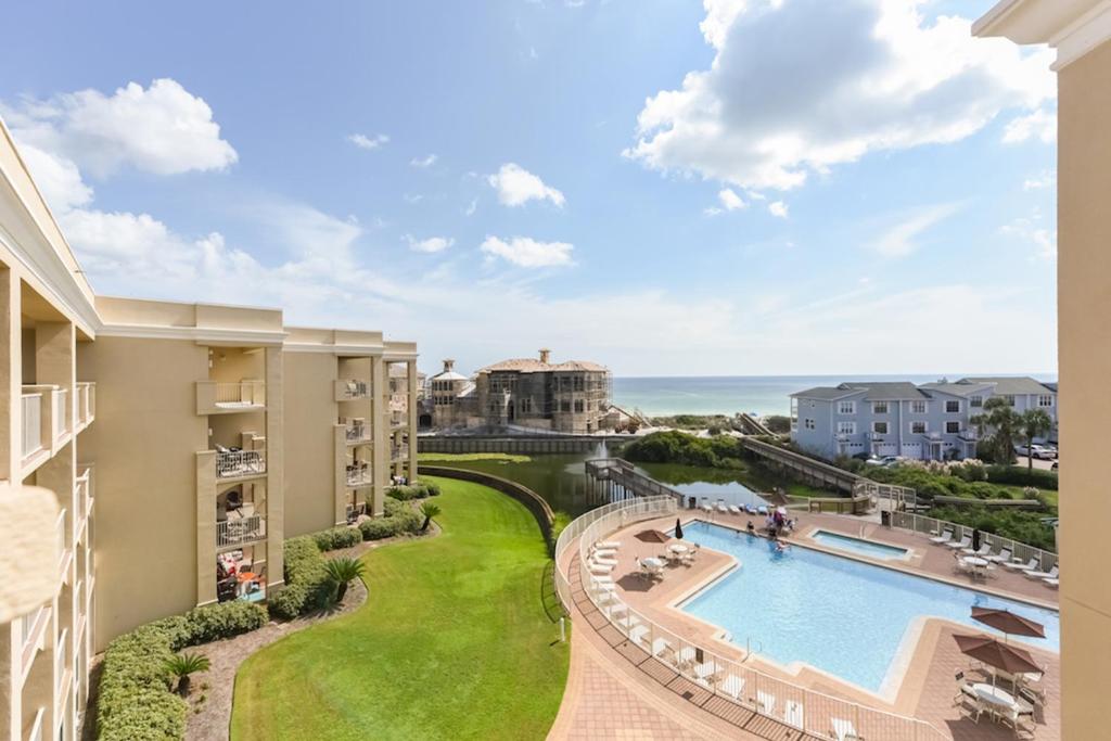 a view of the pool and ocean from the balcony of a resort at San Remo 406 in Santa Rosa Beach