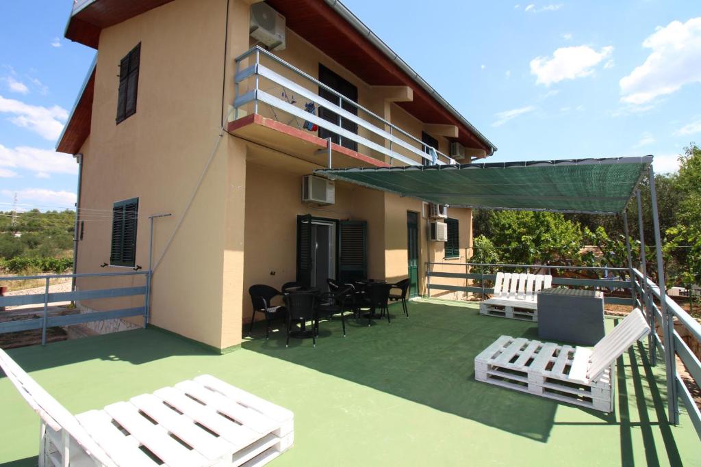- un balcon d'une maison avec des chaises et une table dans l'établissement Hostel Marko, à Tisno