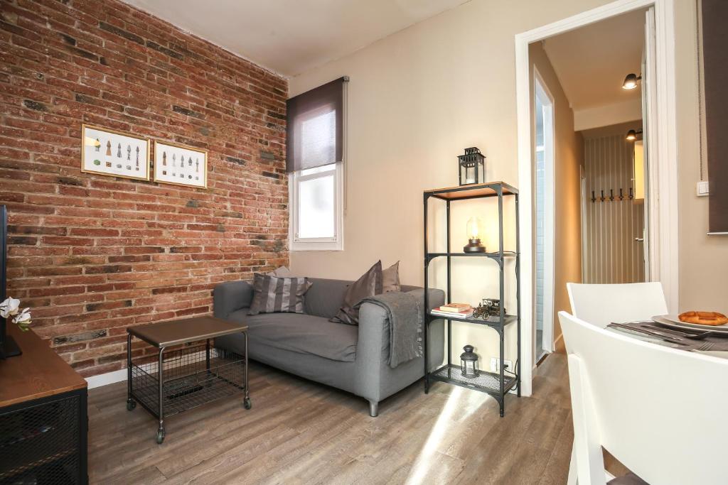 a living room with a couch and a brick wall at Valladolid 19 in Barcelona