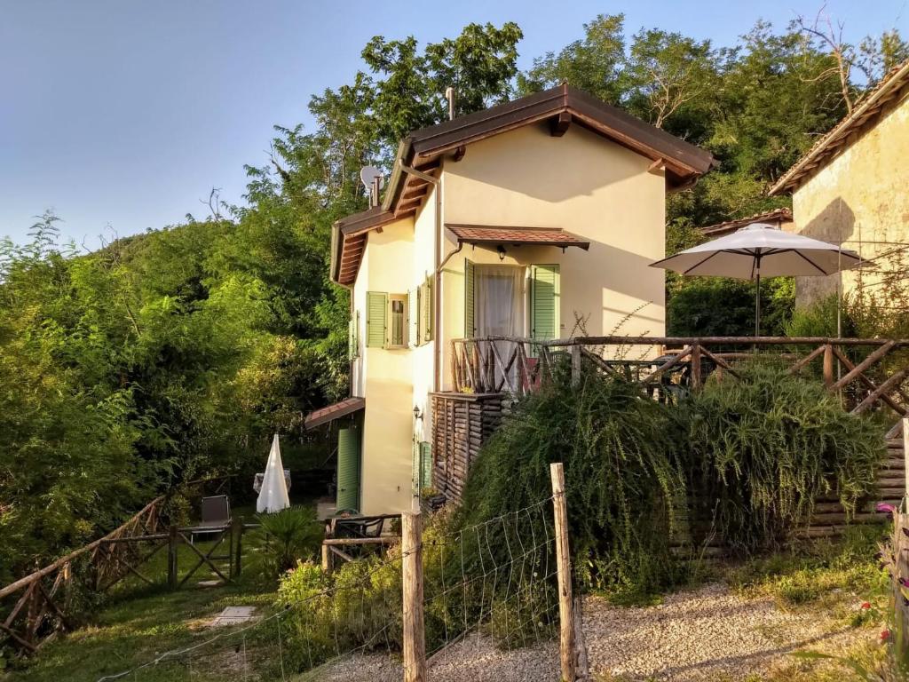 ein Haus mit einem Regenschirm davor in der Unterkunft Casa Di Cinti in Loiano