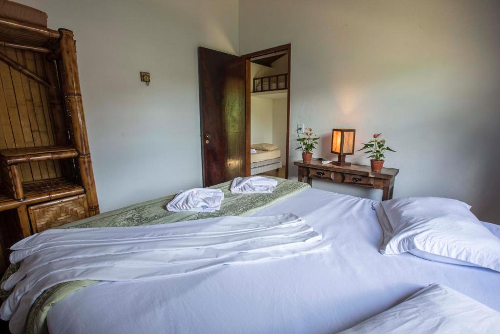um quarto com uma grande cama branca e 2 almofadas em Pousada das Cavernas em Iporanga