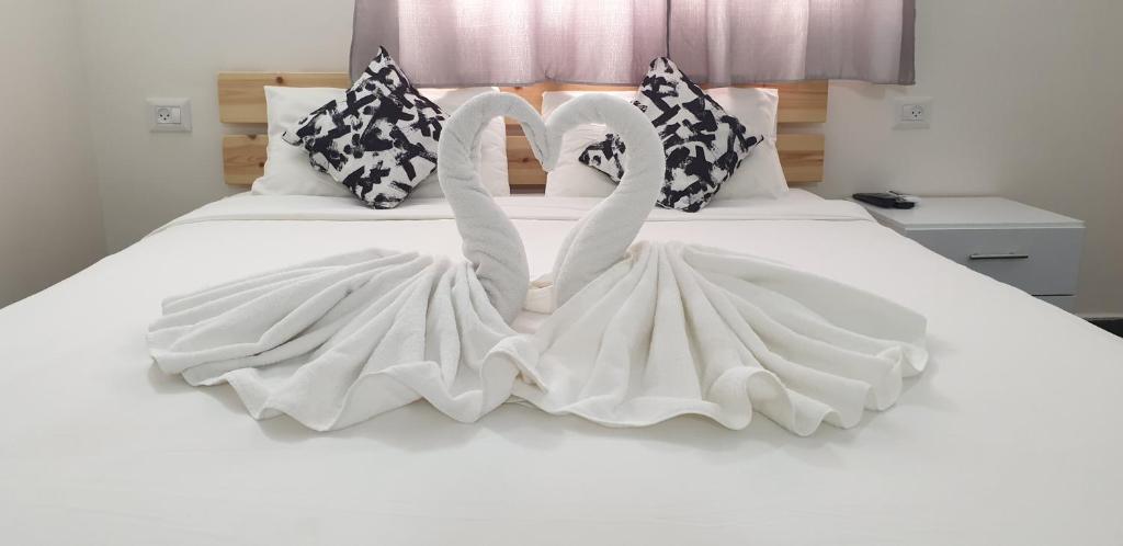 Dos cisnes como si estuvieran en una cama. en David Hameleh House, en Netanya