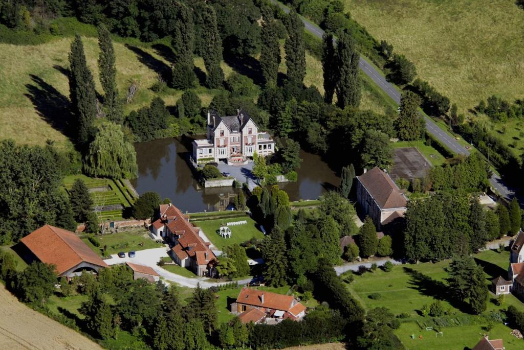 een luchtzicht op een huis met een vijver bij Chateau de Quesmy in Quesmy