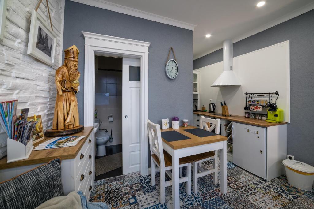 uma cozinha com uma secretária e uma mesa com uma estátua em Apartman Sv. Urban em Bratislava