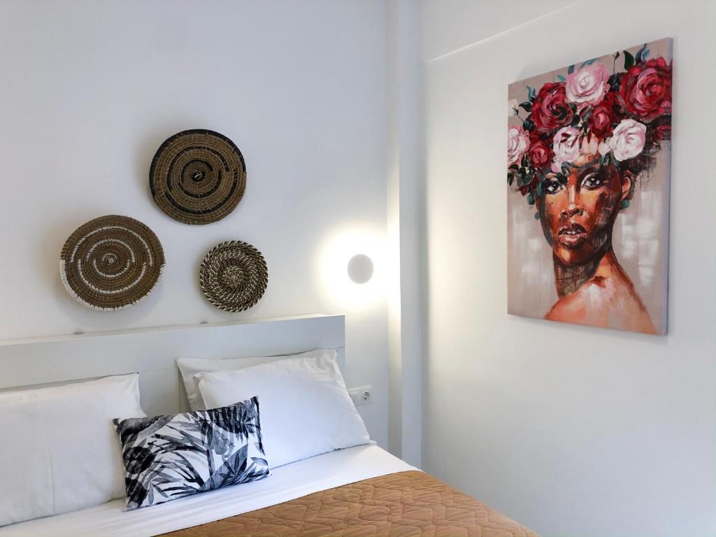 a bedroom with a bed with a painting on the wall at Stelisia Rooms in Chania
