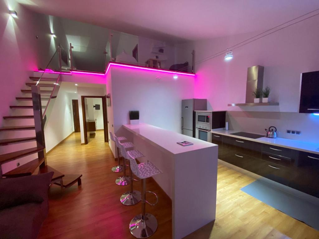 a kitchen with pink lights on the wall and stairs at Modern sea front apartment in Garachico 1 in Garachico