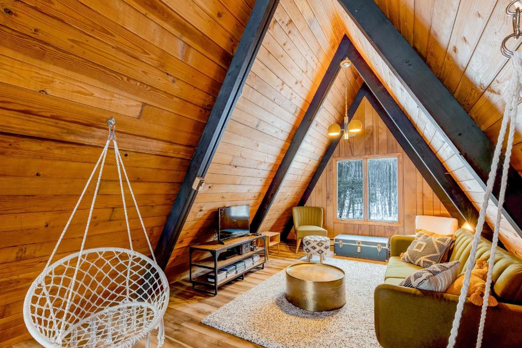ein Wohnzimmer mit einer Schaukel in einer Hütte in der Unterkunft Golden A-Frame in Swanton