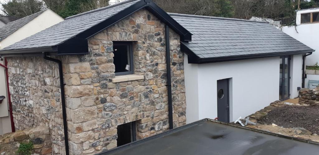 a stone building with a black roof at The Stonehouse, in the heart of Ballycastle in Ballycastle