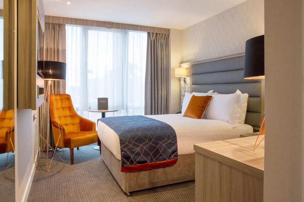 um quarto de hotel com uma cama, uma cadeira e uma secretária em Metro Hotel Dublin Airport em Santry