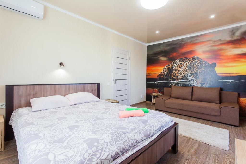 a bedroom with a large bed and a couch at Квартира біля ТРЦ "DREAM TOWN 2" in Kyiv