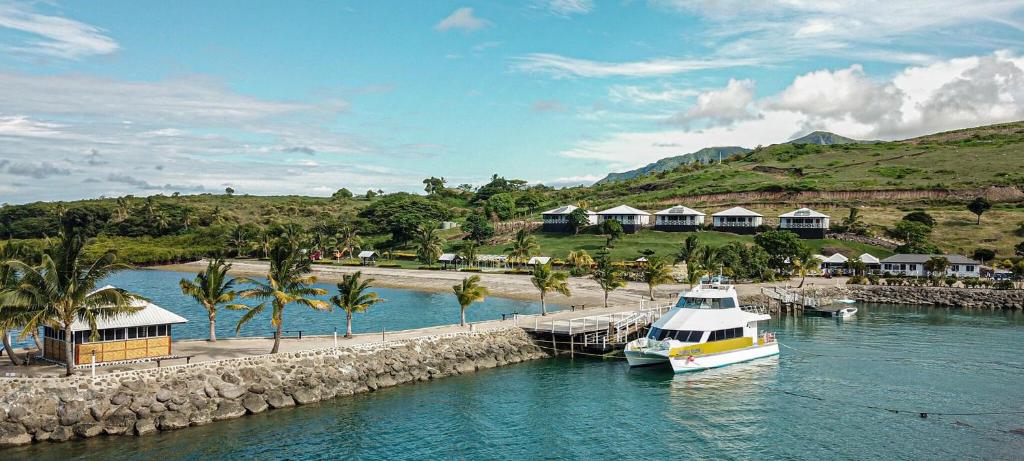 a boat is docked at a dock in the water at Dua Dua Beach Resort in Rakiraki