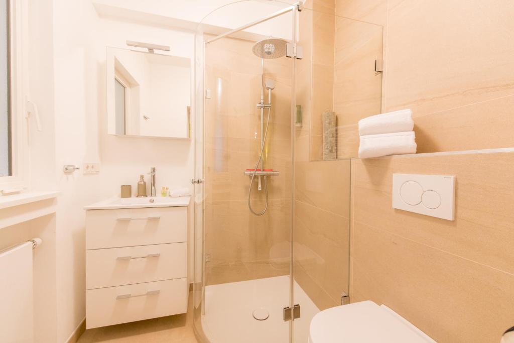 a bathroom with a shower with a toilet and a sink at Berdorfer Eck - Bed&Breakfast in Berdorf