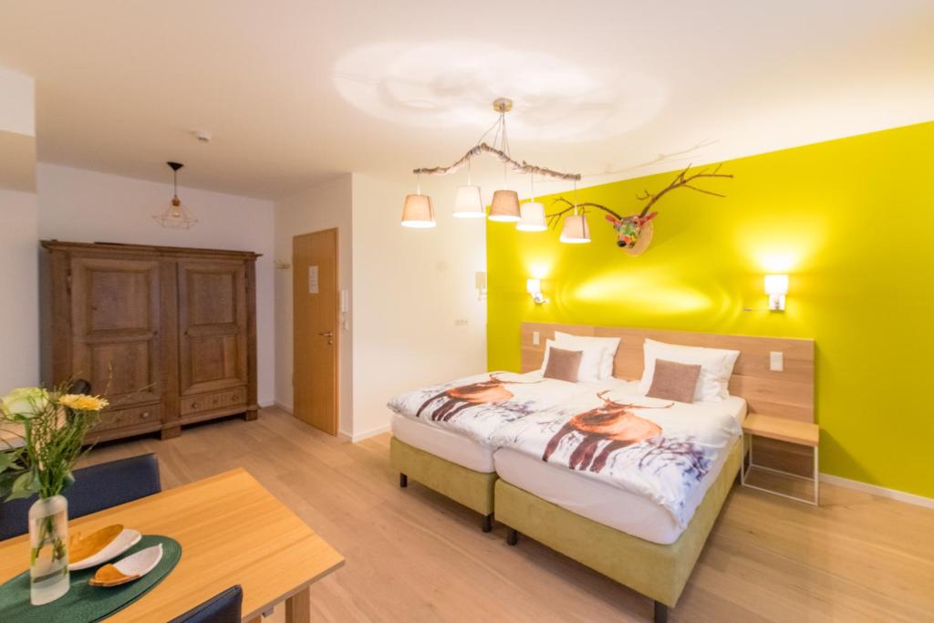 a bedroom with a bed and a yellow wall at Berdorfer Eck - Bed&Breakfast in Berdorf