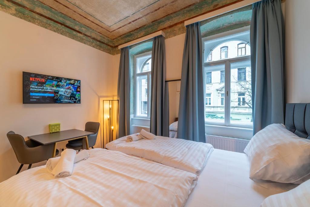 1 Schlafzimmer mit 2 Betten, einem Tisch und einem Fenster in der Unterkunft Agnes I levestate in Wien